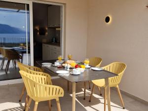 Haus Mit Meerblick في لوبار: طاولة طعام مع كراسي صفراء وطاولة عليها طعام