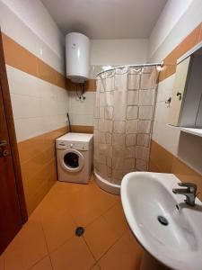 a bathroom with a sink and a washing machine at Sea View Apartments in Durrës