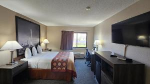 a hotel room with a bed and a flat screen tv at Super 8 by Wyndham Elgin in Elgin