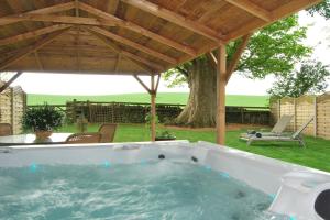 a hot tub under a pavilion in a yard at Dannah Farm Country House in Shottle