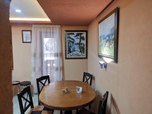 a dining room with a wooden table and chairs at Tarska Svitanja in Mitrovac
