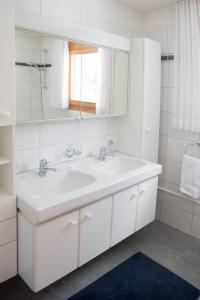 a white bathroom with a sink and a mirror at Holiday apartment La Costa Valbella- Lenzerheide in Valbella +11 photos