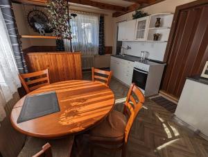 a kitchen with a wooden table and a table and chairs at Dvougenerační dům se zahradou in Vimperk