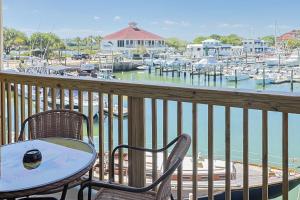 a table and chairs on a balcony with a marina at Inn at Camachee Harbor View 24 in Saint Augustine