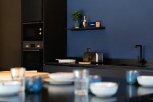 una cocina con una encimera negra con tazones blancos sobre una mesa en Chalet For Friends, en Briançon