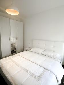 a white bedroom with a large white bed at Sea View Apartments in Durrës