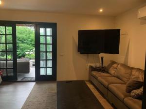a living room with a couch and a flat screen tv at tuinhuis in Harmelen