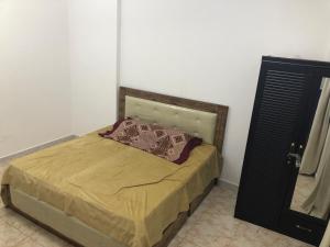 sypialnia z łóżkiem z brązową narzutą w obiekcie Al Majaz King Size Room w Szardży
