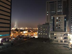 a view of a parking lot in a city at night at Al Majaz King Size Room in Sharjah