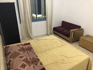 a bedroom with a bed and a chair and a window at Al Majaz King Size Room in Sharjah