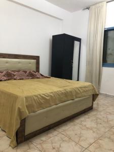 a bedroom with a bed and a black cabinet at Al Majaz King Size Room in Sharjah