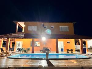 a house with a swimming pool in front of it at Paraíso em Santo Amaro in Santo Amaro