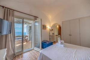 a bedroom with a bed and a sliding glass door at Villa Paolina relaxing in Garden in Anacapri