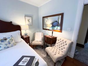 a bedroom with a bed and a chair and a mirror at Lamberson Guest House in Galena
