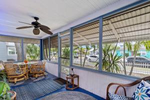 Un porche con ventilador de techo y una mesa y sillas. en The Pineapple Bungalow St Pete, en San Petersburgo 19 fotos más