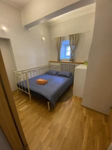 a bedroom with a bed with blue sheets and a window at Kivivete Apartaments in Pärnu