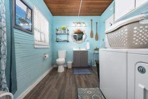 baño con aseo y pared azul en The Lighthouse - Large home close to downtown with a hot tub & game room!, en South Haven 21 fotos más
