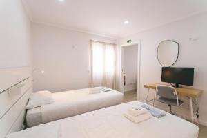 a bedroom with two beds and a desk with a mirror at Best Houses 102 - Hut Spot Peniche in Peniche