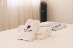 a pile of towels sitting on top of a bed at Best Houses 102 - Hut Spot Peniche in Peniche +23 photos