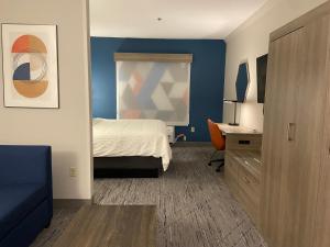 a hotel room with a bed and a desk and a bedroom at Holiday Inn Express & Suites Elyria by IHG in Elyria +11 photos