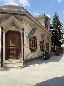 un bâtiment avec une moto garée devant lui dans l'établissement S.J. Homestay, à Dehradun