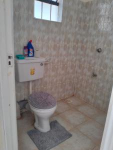 a bathroom with a white toilet and a shower at Yalacosy homes in Kitengela 