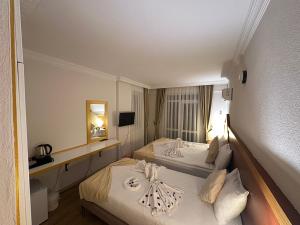Habitación de hotel con 2 camas y espejo en Far Life Hotel, en Antalya
