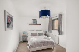 - une chambre avec un lit et une lampe suspendue bleue dans l'établissement Marine parade apartment with river view, à Dundee