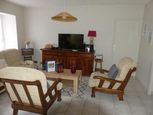 a living room with two rocking chairs and a tv at Gîte de NOE au Ray-pic in Péreyres
