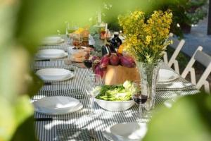 einen Tisch mit Tellern und Gläsern aus Wein und Blumen in der Unterkunft Ferienhaus für 10 Personen in Terranuova Bracciolini, Toskana Provinz Arezzo in Terranuova Bracciolini