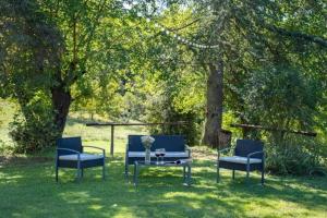 trois chaises bleues et une table dans l'herbe dans l'établissement Ferienhaus mit Privatpool für 10 Personen ca 300 qm in Terranuova Bracciolini, Toskana Provinz Arezzo, à Terranuova Bracciolini