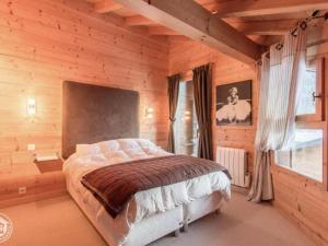 1 dormitorio con 1 cama en una cabaña de madera en Chalet Nina, en La Chapelle-dʼAbondance
