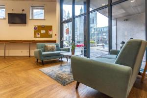 uma sala de espera com cadeiras, uma mesa e uma televisão em For Students Only Private Ensuite Rooms with Shared Kitchen at Pittrodrie Street em Aberdeen