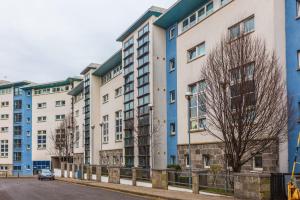 uma fila de edifícios de apartamentos brancos e azuis em For Students Only Private Ensuite Rooms with Shared Kitchen at Pittrodrie Street em Aberdeen