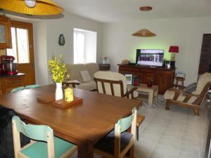 a living room with a wooden table and chairs at Gîte de NOE au Ray-pic in Péreyres +35 photos