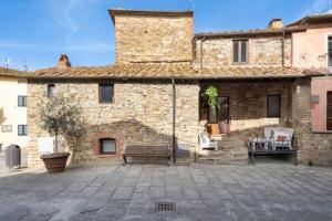 een stenen gebouw met een bank ervoor bij Ferienhaus für 6 Personen ca 130 qm in Pergine Valdarno, Toskana Provinz Arezzo in Pergine Valdarno
