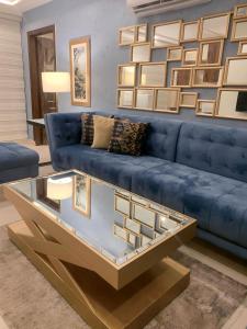un soggiorno con divano blu e tavolo in vetro di Montage Apartments a Rāmkot