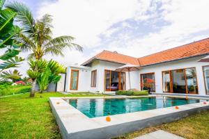 een huis met een zwembad in de tuin bij Villa Sawah Ramah in Ubud