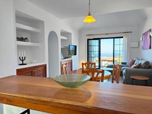 Una cocina y una sala de estar con una mesa de madera. en Casa María, en Tías