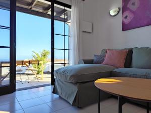 una sala de estar con un sofá y una mesa en Casa María, en Tías