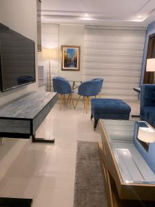 sala de estar con mesa y sillas azules en Montage Apartments en Rāmkot