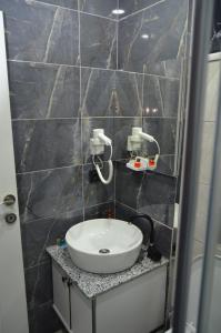 ein Badezimmer mit einem Waschbecken in einer gefliesten Wand in der Unterkunft SEZGİN KARGI - Günübirlik Turizm Evleri in Akçatepe + 8 Fotos