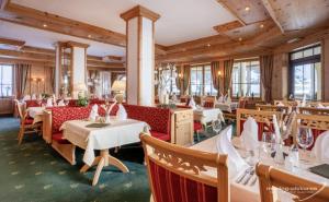 un restaurante con mesas, sillas y ventanas en Hotel Venter Bergwelt, en Vent