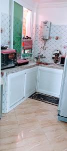 uma cozinha com portas brancas e piso em azulejo em Stay 3 km near to Airport Fes Saiss em Fez