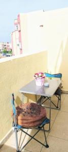 une table et une chaise avec un bol de fleurs dans l'établissement Stay 3 km near to Airport Fes Saiss, à Fès