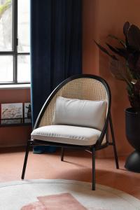 een rotan stoel met een wit kussen in een kamer bij Interno Marche Design Experience Hotel in Tolentino