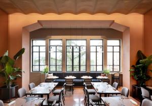 a restaurant with tables and chairs and windows at Interno Marche Design Experience Hotel in Tolentino