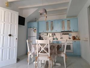 a kitchen with blue cabinets and a table and chairs at Faro del mar in Naxos Chora