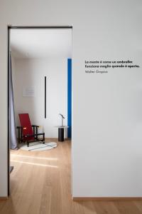 una puerta abierta a una habitación con una silla roja en Interno Marche Design Experience Hotel, en Tolentino
