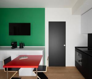 Habitación con una mesa roja y una pared verde. en Interno Marche Design Experience Hotel, en Tolentino